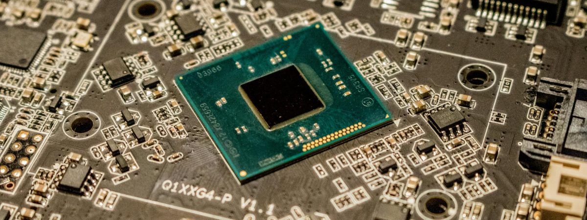 Detailed view of a microchip on a printed circuit board, showcasing electronic components. About Edwin's One Stop Computer Repair Shop